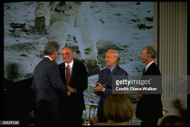 Pres. Clinton shaking hands w. Apollo 11 astronauts Neil Armstrong, Buzz Aldrin & Michael Collins in 25th moon landing anniv. Fete at WH.