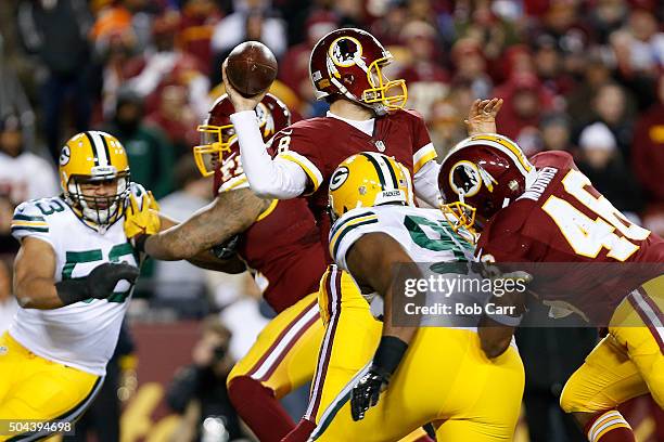 Quarterback Kirk Cousins of the Washington Redskins drops back to pass while teammate running back Alfred Morris blocks against defensive end Datone...