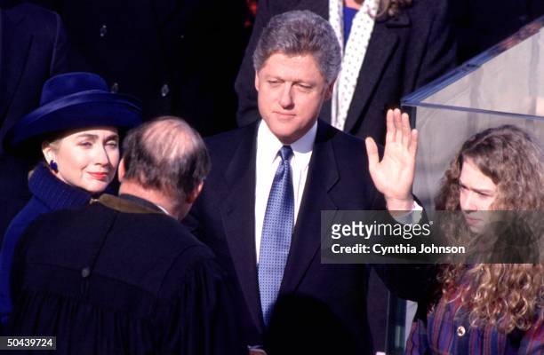 Pres. Bill Clinton, wife Hillary Rodham Clinton & daughter Chelsea looking on, being sworn in to office by Chief Justice Rehnquist.