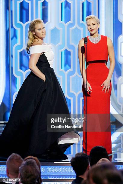 In this handout photo provided by NBCUniversal, Presenters Amy Schumer and Jennifer Lawrence speak onstage during the 73rd Annual Golden Globe Awards...