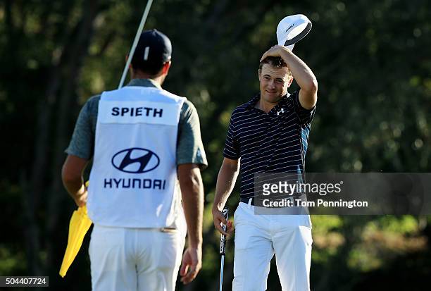 Jordan Spieth celebrates with caddie Michael Greller on the 18th green after putting for birdie to go 30 under and win the final round of the Hyundai...