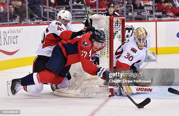 Patrick Wiercioch of the Ottawa Senators knocks down T.J. Oshie of the Washington Capitals as he shoots on Andrew Hammond at the Verizon Center on...