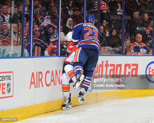 Matt Hendricks of the Edmonton Oilers lands a big hit on Aaron Ekblad of the Florida Panthers on January 10, 2016 at Rexall Place in Edmonton,...