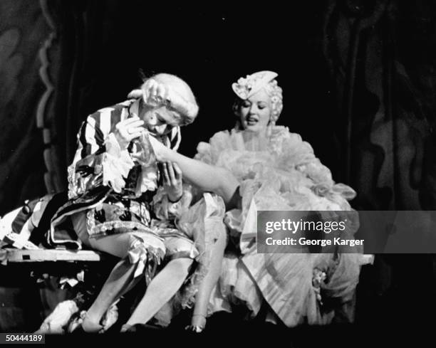 Actor Bert Lahr as Louis XV, lecherously kissing the foot of actress Betty Grable as a Court of Versailles cortesan in the Broadway production of...