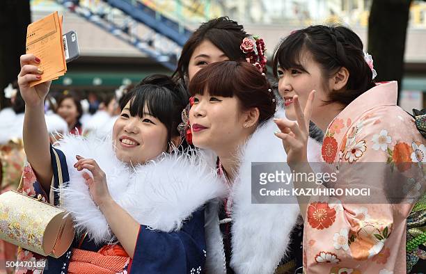 Twenty-year-old women wearing kimonos pose together for photos after attending a "Coming-of-Age Day" celebration at the Toshimaen amusement park in...