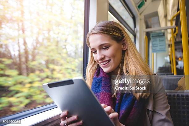 using digital tablet on the train - man woman train station stockfoto's en -beelden