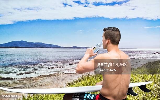 surfer drinking water from bottle - beach clear sky stock pictures, royalty-free photos & images