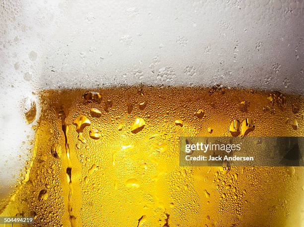 overfull glass of beer with condensation - bier stockfoto's en -beelden