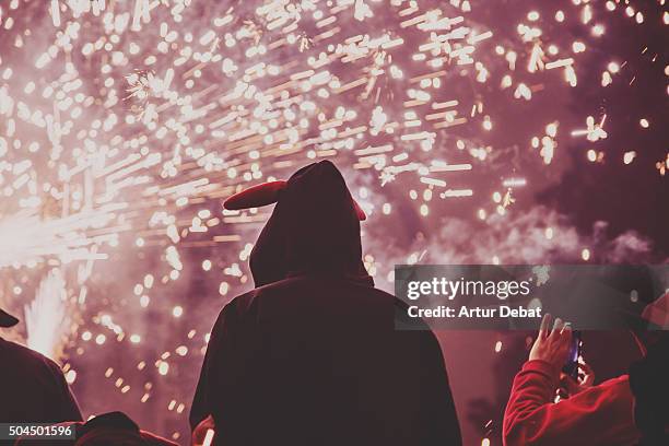 people in the correfocs tradition festivity at night in the city with bokeh and colorful sparks. - correfoc stockfoto's en -beelden