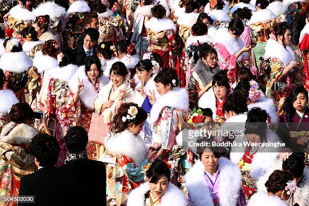 Men and women dressed in Kimono and suits attend the Coming of Age Day ceremony outside of Noevir Stadium on January 11, 2016 in Kobe, Japan. The...