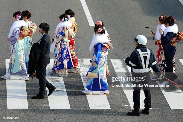 Men and women dressed in Kimono and suits attend the Coming of Age Day ceremony outside of Noevir Stadium on January 11, 2016 in Kobe, Japan. The...