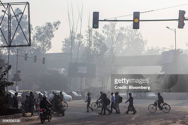 Pedestrians cross a road as traffic sits at traffic lights shrouded in smog in New Delhi, India, on Monday, Jan. 11, 2016. A 2-judge Delhi High Court...