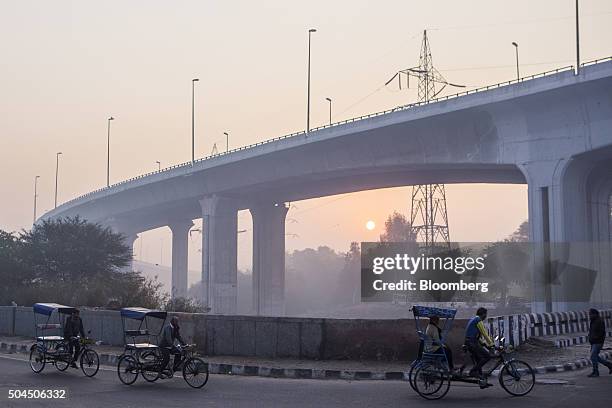 Rickshaws travel along a road shrouded in smog in New Delhi, India, on Monday, Jan. 11, 2016. A 2-judge Delhi High Court panel headed by Chief...