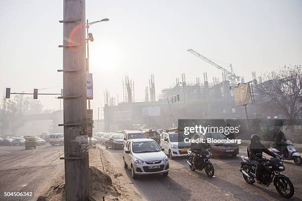 Traffic drives along a road shrouded in smog in New Delhi, India, on Monday, Jan. 11, 2016. A 2-judge Delhi High Court panel headed by Chief Justice...