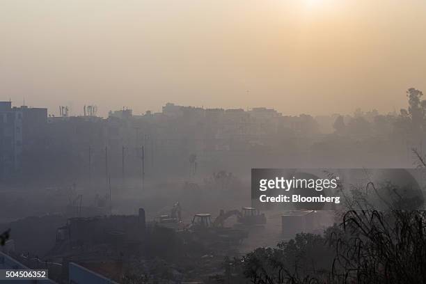 Construction equipment sits idle at a site shrouded in smog in New Delhi, India, on Monday, Jan. 11, 2016. A 2-judge Delhi High Court panel headed by...