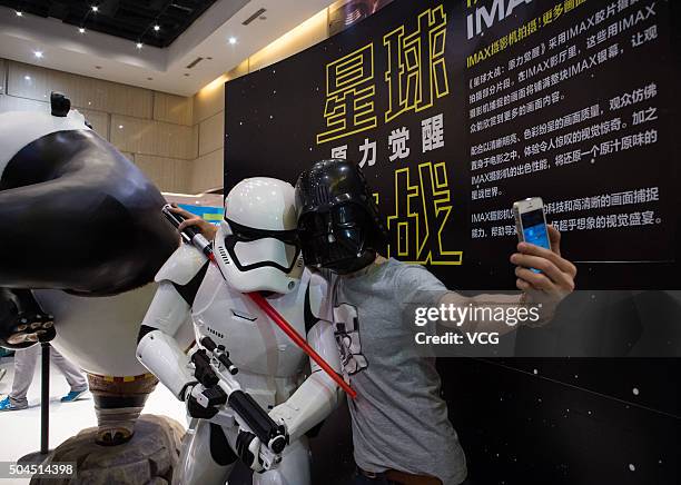 Fan wearing a black mask poses with a solider when waits for the premiere of "Star Wars: The Force Awakens" at a cinema on January 9, 2015 in...