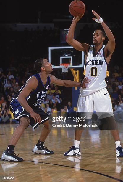 Guard Leon Jones of the Michigan Wolverines looks to pass over forward Dahntay Jones of the Duke Blue Devils during the NCAA basketball game at...