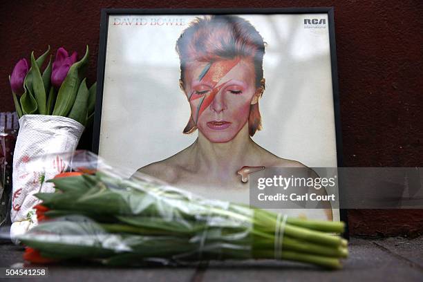 Picture and flowers are left beneath a mural of David Bowie in Brixton on January 11, 2016 in London, England. British music and fashion icon David...