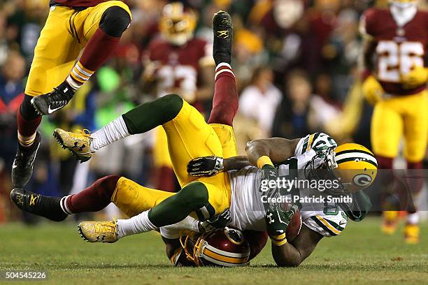 Wide receiver James Jones of the Green Bay Packers is tackled by cornerback Will Blackmon of the Washington Redskins while free safety Dashon Goldson...