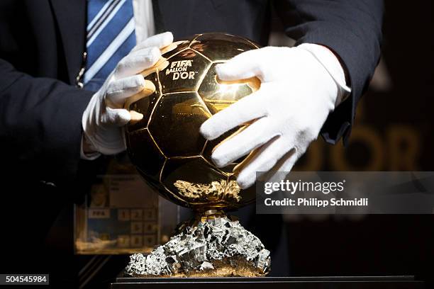 Volunteer places the FIFA Ballon d'Or trophy on a display for a press conference prior to the FIFA Ballon d'Or Gala 2015 at the Kongresshaus on...