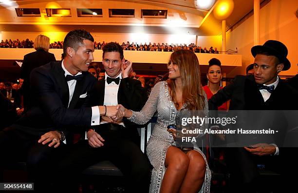 Ballon d'Or nominee Cristiano Ronaldo of Portugal and Real Madrid shakes hands with Antonella Roccuzzo as he sits with fellow nominees Lionel Messi...