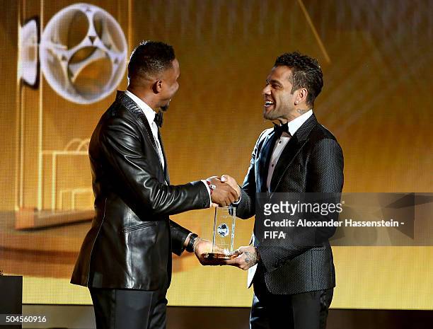 Dani Alves of Brazil and Barcelona receives his award from Samuel Eto'o after being announced in the FIFA FIFPro World XI for 2015 during the FIFA...