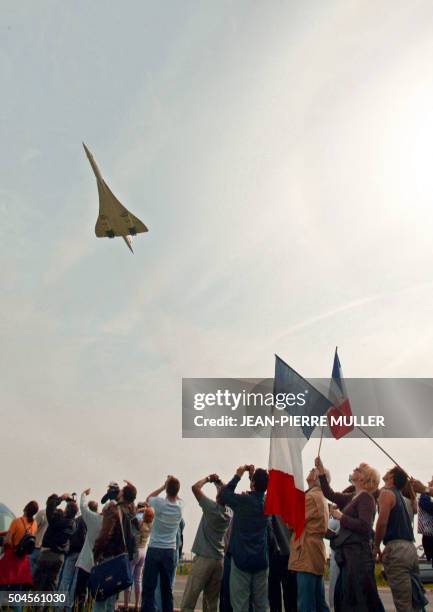 Des personnes regardent le décollage du supersonique Concorde en bout de piste de l'aéroport de Roissy-Charles de Gaulle, le 11 mai 2003 aux abords...