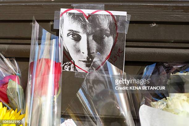 David Bowie's face it's seen on a poster at a memorial outside of the residence of British music legend David Bowie in New York on January 11, 2016....