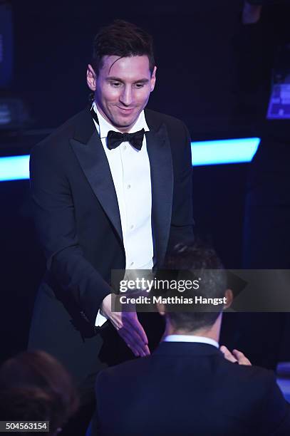 Lionel Messi of Argentina and FC Barcelona the winner of the Ballon d'or is congratulated by Cristiano Ronaldo of Portugal and Real Madrid during the...