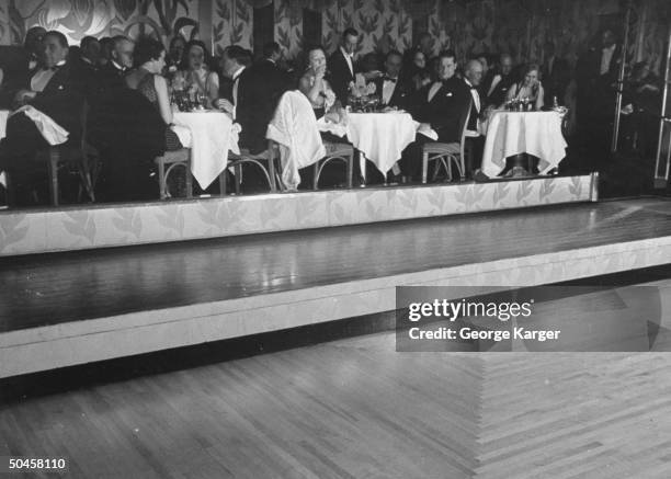 People sitting at tables watching an ice rink move out over the dancefloor at the Iridium Room at the St. Regis Hotel.