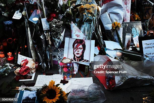 Flowers, candles and pictures sit at a memorial outside of the late musician and performer David Bowie's apartment that he shared with his wife on...