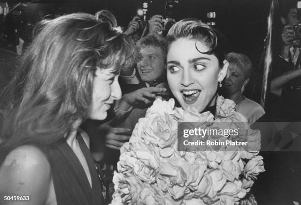 Actress Jennifer Grey chatting w. Singer Madonna at Tony Awards party at Sardi's restaurant.