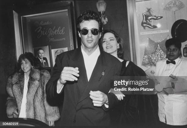Actor Sly Stallone wearing dark glasses w. Actress Janine Turner at film premiere.