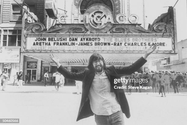 Motion picture director John Landis standing in front of a movie theatre marquee announcing his motion picture The Blues Brothers.