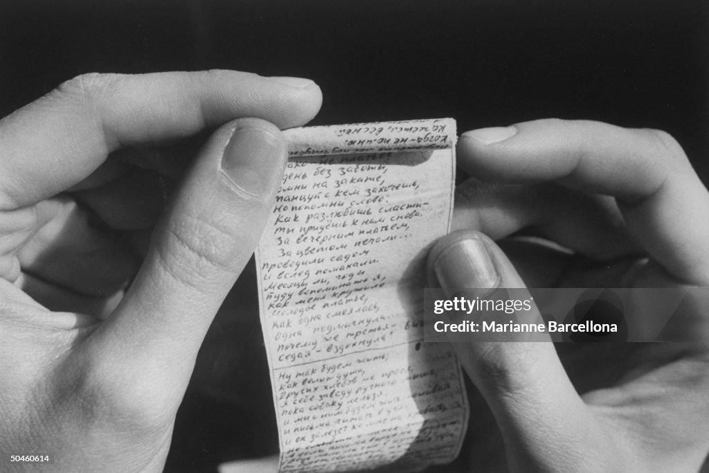 Closeup of hands holding poems, written
