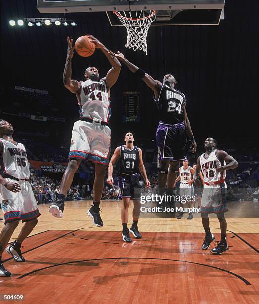 Foward Tony Massenburg of the Memphis Grizzlies rebounds the ball as guard Bobby Jackson also attempts to rebound during the NBA game against the...