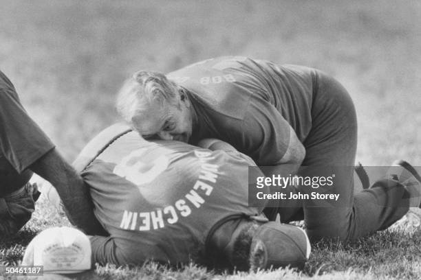 Old football players, Bob Clegg & Loren Blumenshein on the ground wrestling for a fumble during Codger Bowl football game; a 50 yr. Rematch using...