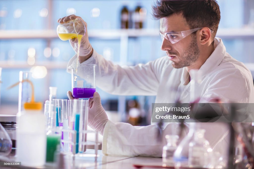 Young scientist working on scientific experiment with chemical substances.