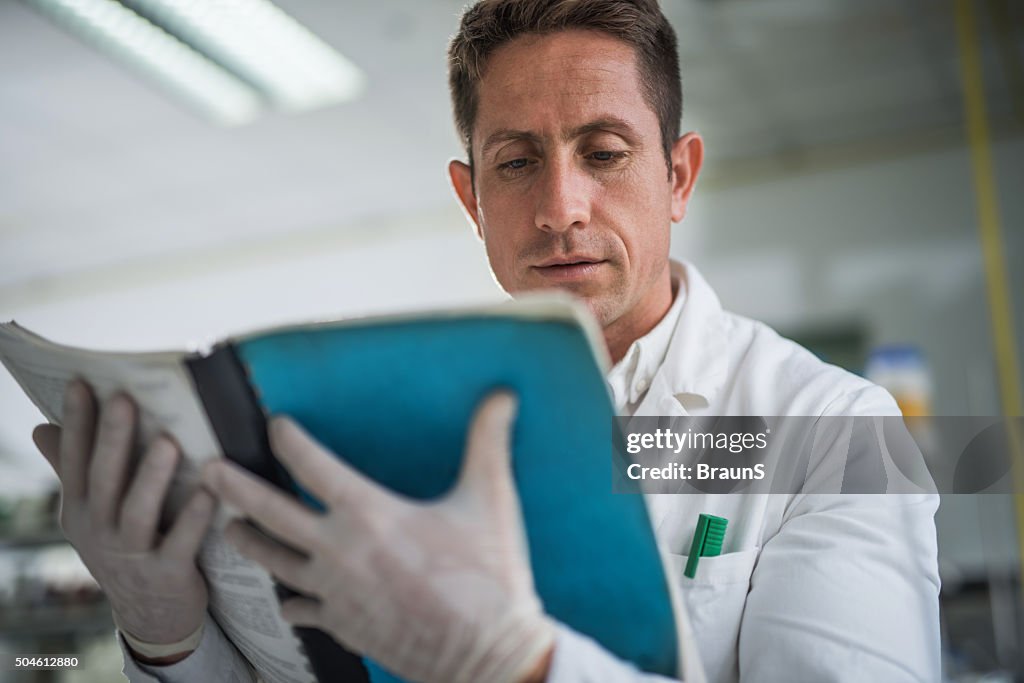 Doctor searching something in a book for his medical research.