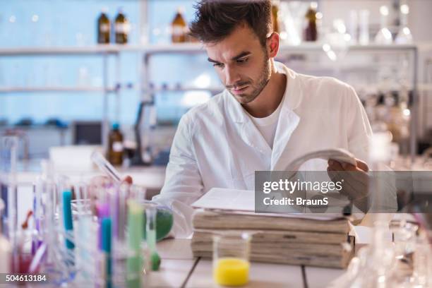 young scientist reading scientific data in a laboratory. - article stock pictures, royalty-free photos & images