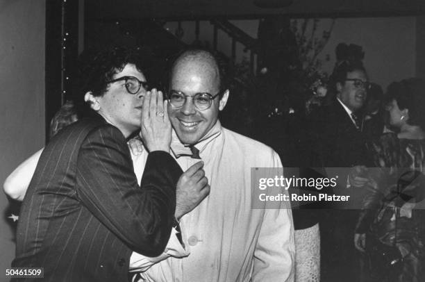 Gossip columnist, w. Michael Musto whispering in the ear of NY gossip columnist William Norwich at NEW YORK magazine's 20th anniversary party.