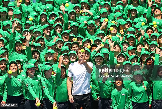 Andy Murray of Great Britain and ballkids from Australia and overseas throw tennis balls in the air during the annual ballkid team photo ahead of the...