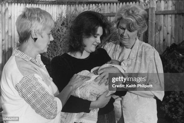 Anti-abortion activists Carol Armstrong & Anne O'Brien looking on as Stacey Feit cradles her 7 day old son, Zachary.