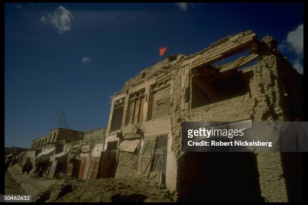 Red flag flying fr. Govt. Post in war torn city largely destroyed in 10 yrs. Of govt. Vs. Mujahedeen fighting, now enjoying fragile peace.