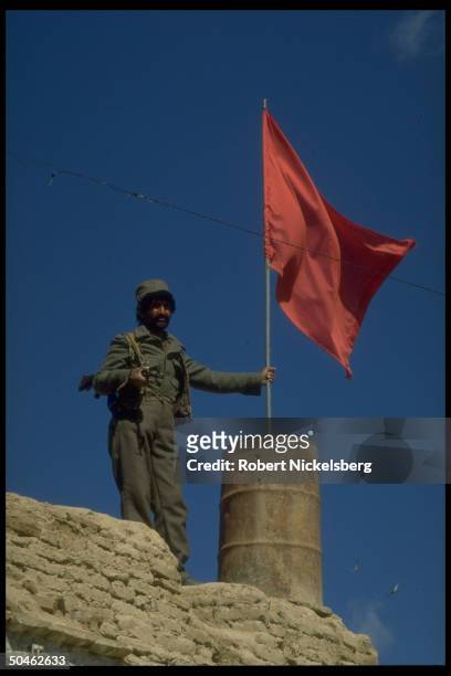 Soldier guarding red flag topped govt. Post in war torn city devastated by 10 yrs. Of govt./ Mujahedeen fighting, now enjoying fragile peace.