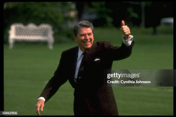 Pres. Ronald Reagan walking & giving thumbs up gesture on S. Lawn after returning from MA.