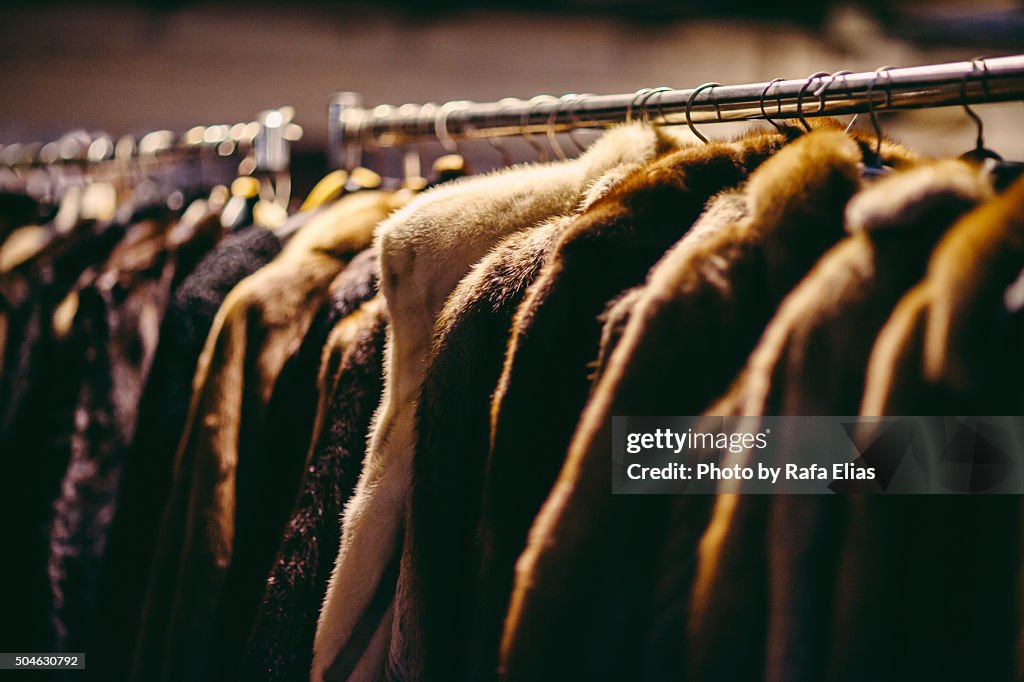 Hanging fur coats on clothes rack