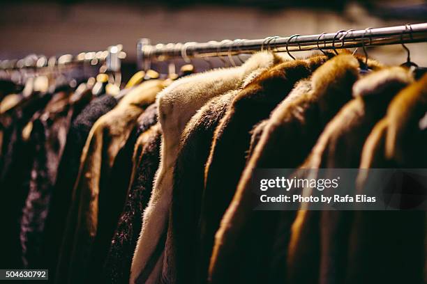 hanging fur coats on clothes rack - fake fur stock pictures, royalty-free photos & images