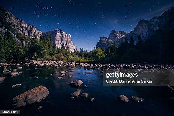 the milky way over el capitan and half dome mountain from merced river, yosemite national park, california, united states. - yosemite daniel stock-fotos und bilder