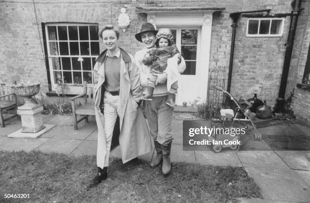 Cabaret performer Kit Hesketh-Harvey with wife Kate and daughter Augusta in front of their house; Norfolk, East Anglia.